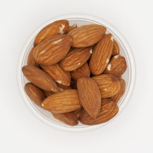 Small Pile of Raw Almonds In A Container On A White Background
