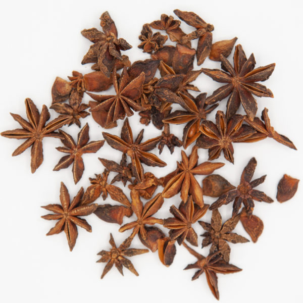 A variety of whole anise star spices on a white backbground