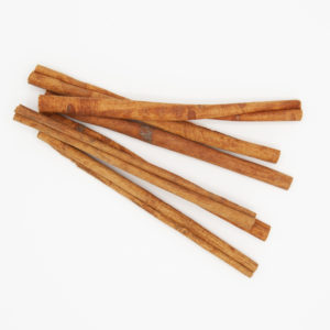 Pile of 5 Six Inch Cinnamon Sticks Detailed Spice Textures From Above On White Background