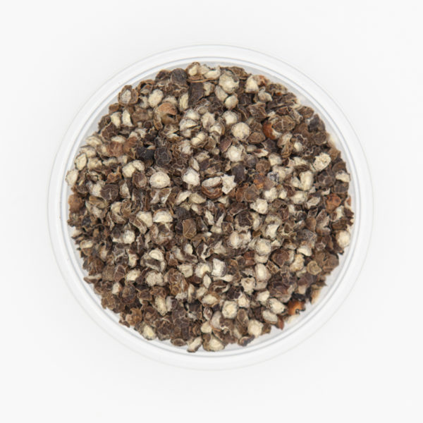 Closeup of Black Cracked Pepper in small dish on white background